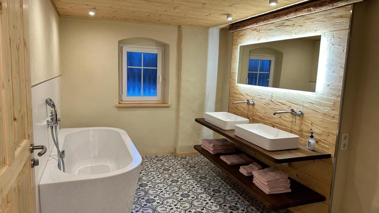Badezimmer mit freistehender Wanne, Doppelwaschtisch und gemustertem Zementfliesenboden